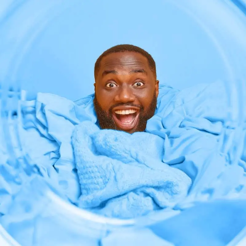 Man doing laundry at Emerald Waves Laundromat.