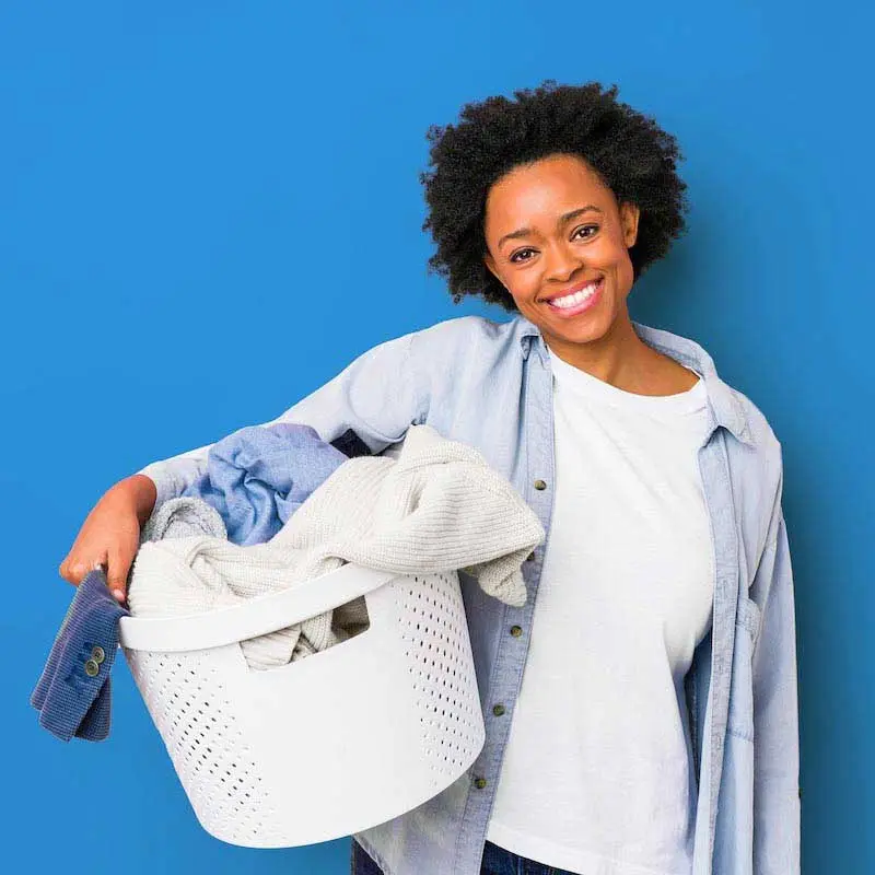 Woman holding a basket of fresh, clean folded laundry.